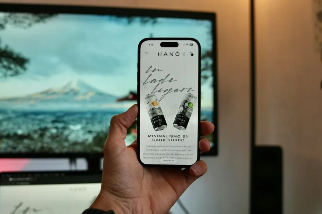 Hand holding smartphone displaying website with drinks.